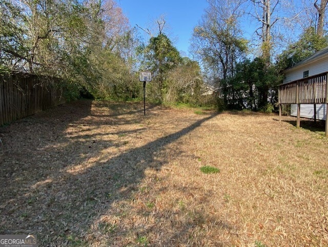 view of yard featuring fence and a wooden deck