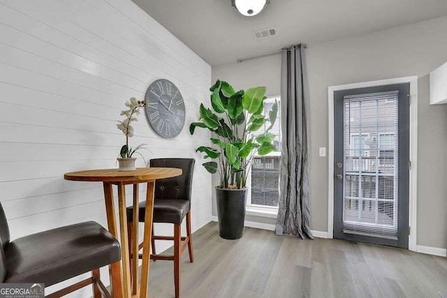 dining space with wood finished floors, visible vents, and baseboards