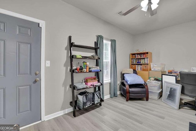 home office featuring light wood finished floors, a ceiling fan, visible vents, and baseboards