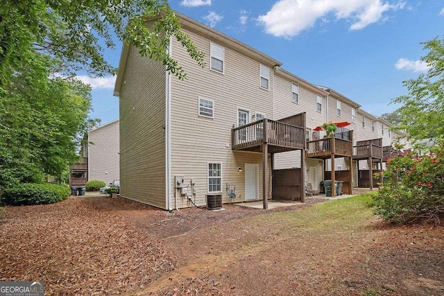 back of house with a deck and central AC unit