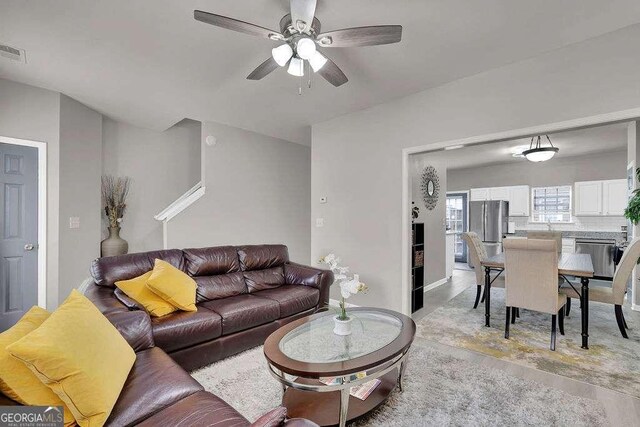 living area featuring visible vents, a ceiling fan, and light wood-style floors