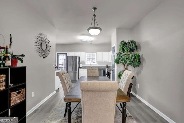 dining room with light wood-type flooring and baseboards