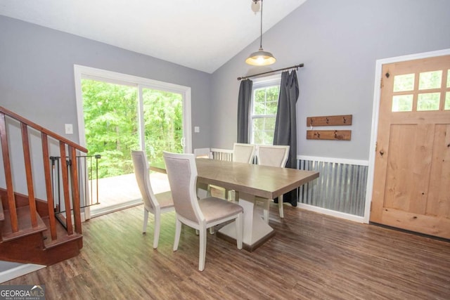 dining area with stairway, wood finished floors, and vaulted ceiling