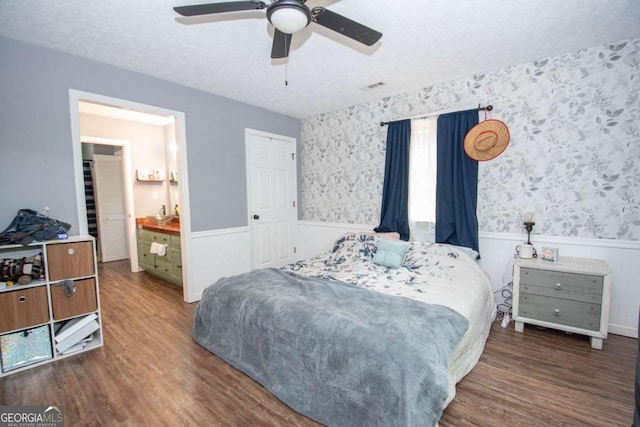 bedroom with visible vents, wainscoting, wood finished floors, and ceiling fan