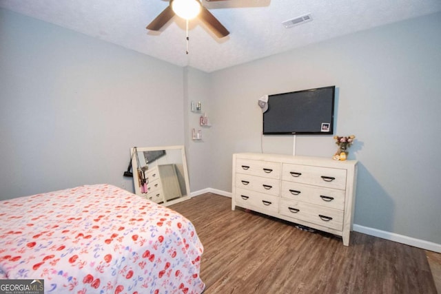 bedroom with baseboards, visible vents, wood finished floors, and ceiling fan