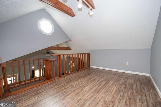 additional living space with a ceiling fan, lofted ceiling, wood finished floors, and baseboards