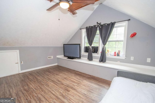 interior space with lofted ceiling, wood finished floors, and baseboards