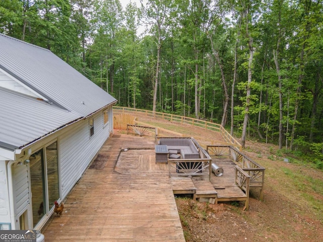 view of yard featuring a deck and a forest view