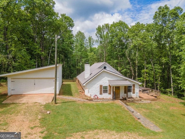 view of front of home featuring an outbuilding, a front yard, a garage, and a chimney