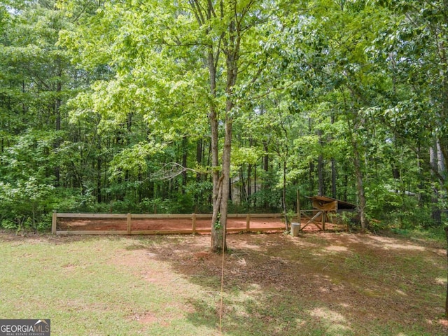 view of yard with fence and a forest view