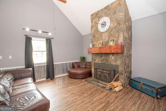 living room with vaulted ceiling, wood finished floors, and a fireplace
