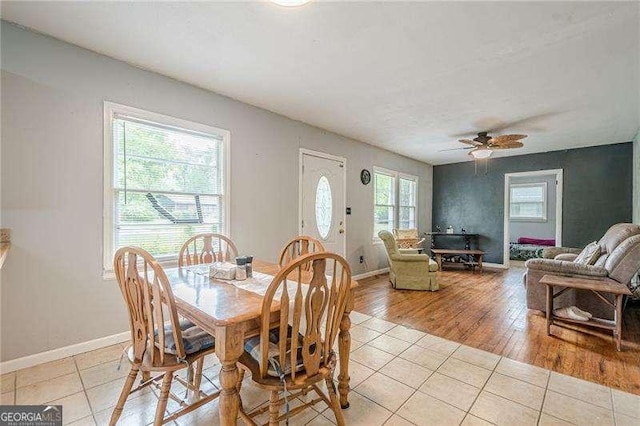 dining area with light tile patterned flooring, a ceiling fan, and baseboards