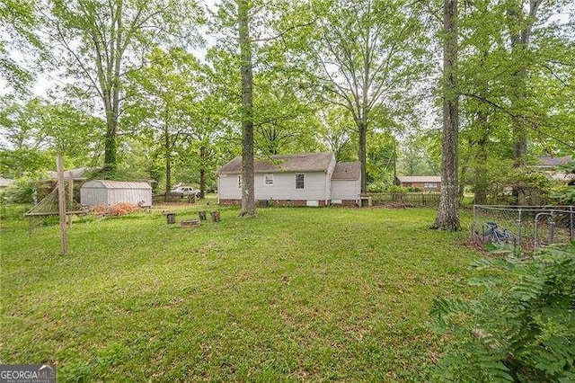 view of yard with an outbuilding, a storage shed, and fence