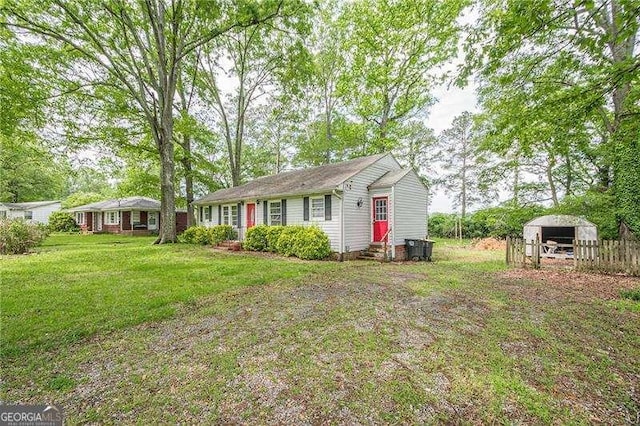 exterior space with fence, a carport, entry steps, and a front lawn