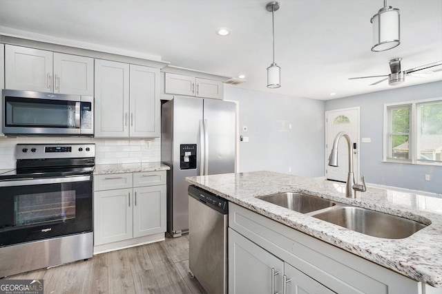 248 Upshaw St SW, Atlanta, GA 30315 - kitchen featuring stainless steel appliances, light wood finished floors, hanging light fixtures, recessed lighting, and backsplash