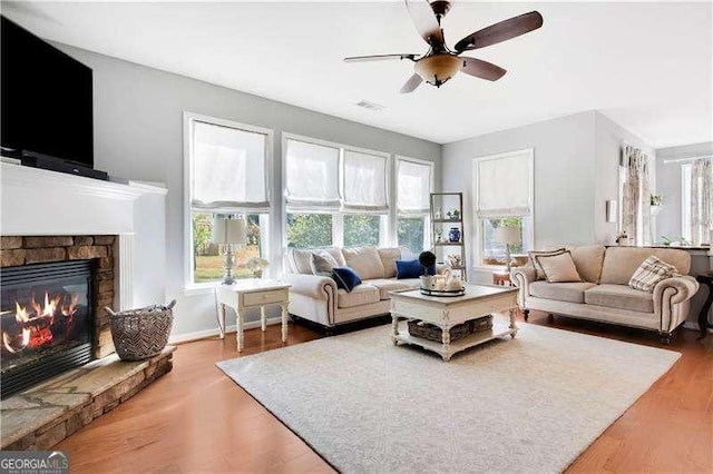 233 Hampton Station Blvd, Canton, GA 30115 - living area with a ceiling fan, a stone fireplace, plenty of natural light, and wood finished floors