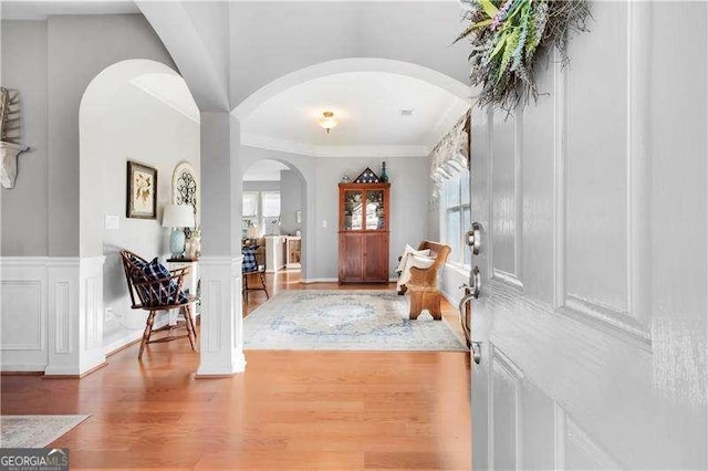 233 Hampton Station Blvd, Canton, GA 30115 - foyer entrance with arched walkways, wood finished floors, a wainscoted wall, ornamental molding, and a decorative wall