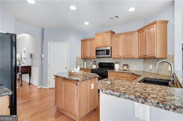 233 Hampton Station Blvd, Canton, GA 30115 - kitchen with light stone countertops, a sink, arched walkways, visible vents, and black appliances