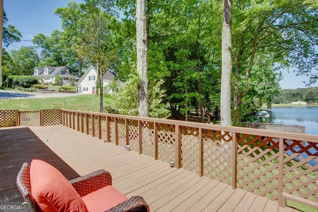 wooden terrace with a water view and view of scattered trees