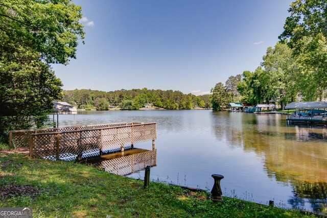 dock featuring a water view and a forest view