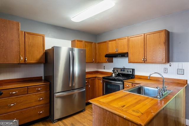 2240 Lake Dr NE, Conyers, GA 30012 - kitchen featuring stainless steel appliances, under cabinet range hood, a sink, butcher block countertops, and brown cabinetry