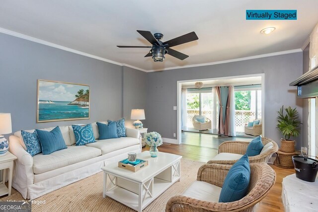 living area featuring wood finished floors, ceiling fan, baseboards, and ornamental molding