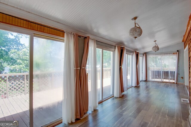 unfurnished sunroom with wood finished floors and vaulted ceiling