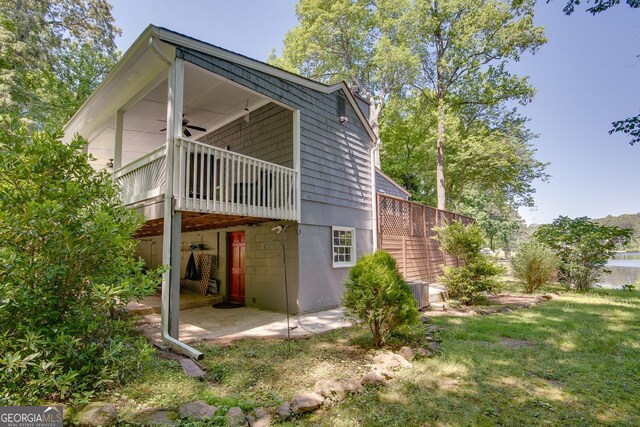 rear view of house with a patio area, a yard, and a deck