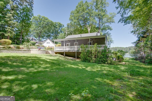 2240 Lake Dr NE, Conyers, GA 30012 - rear view of property featuring a lawn, a sunroom, a deck, ceiling fan, and a chimney