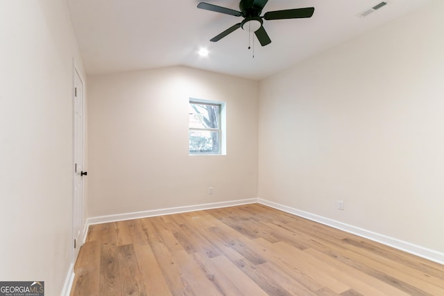 empty room with ceiling fan, visible vents, light wood-style flooring, baseboards, and lofted ceiling