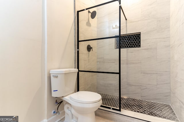 full bathroom with baseboards, a shower stall, and toilet