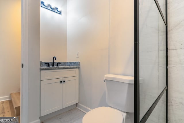bathroom featuring baseboards, toilet, and vanity