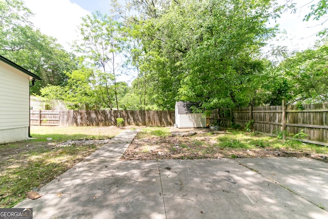 view of yard featuring an outdoor structure, a storage shed, a fenced backyard, and a patio area