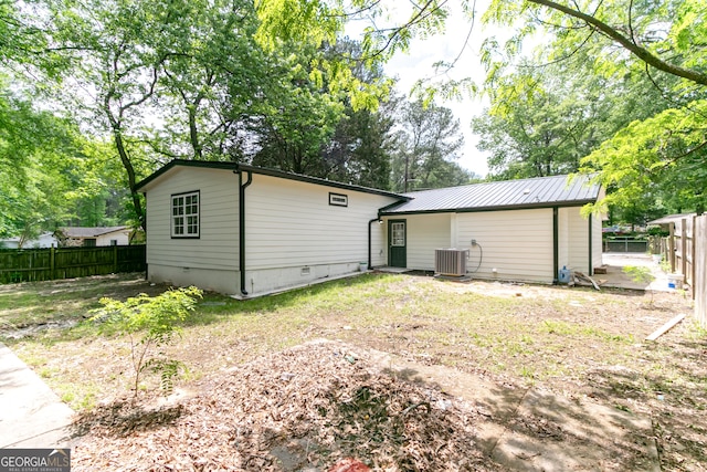 back of house featuring metal roof, central air condition unit, crawl space, and a fenced backyard
