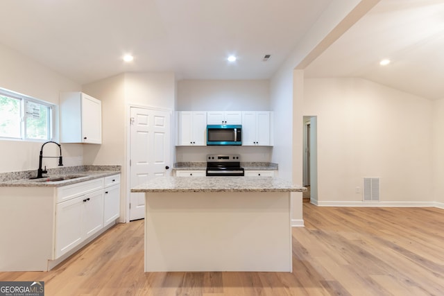 kitchen with a sink, visible vents, light stone counters, white cabinets, and appliances with stainless steel finishes