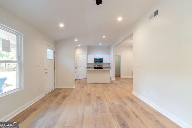 interior space with recessed lighting, light wood-style floors, ceiling fan, baseboards, and visible vents