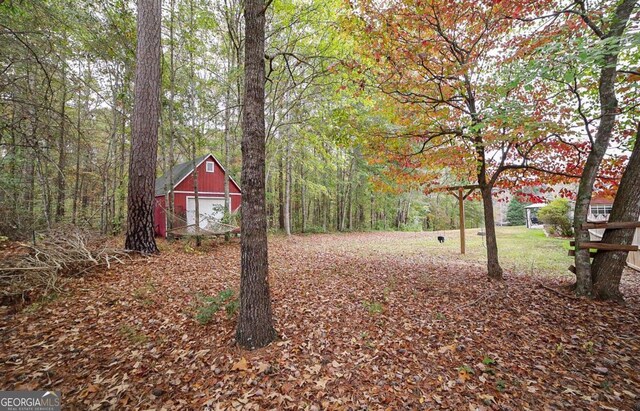 95 Blue Grass Ct, Oxford, GA 30054 - view of yard featuring an outdoor structure, a forest view, and a garage