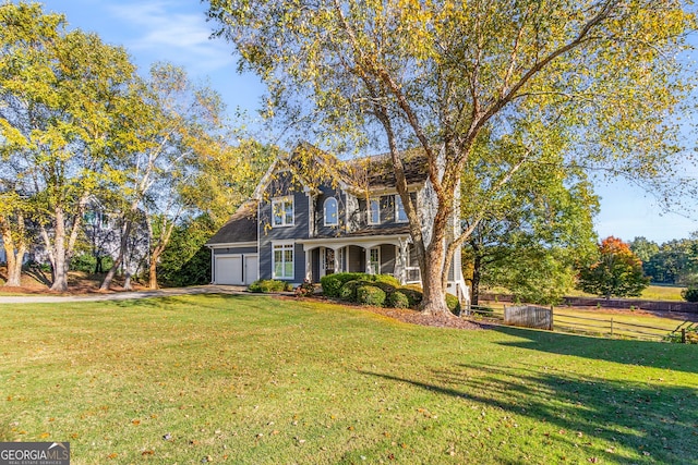 view of front of property with a porch, a front yard, driveway, and fence