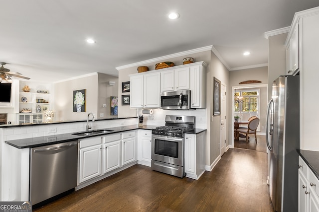 kitchen with a sink, stainless steel appliances, crown molding, a ceiling fan, and a peninsula