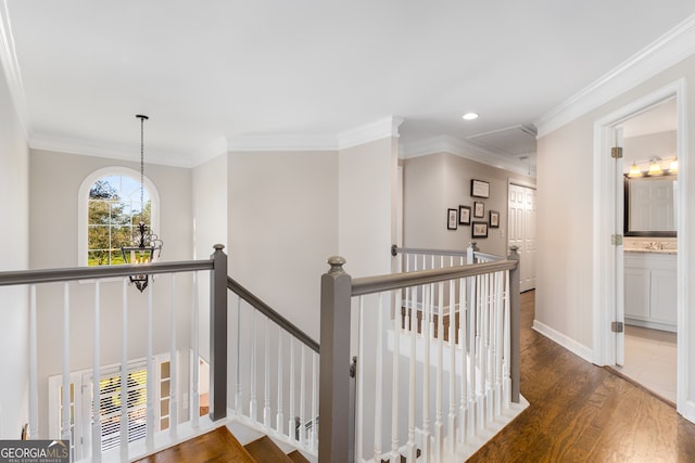 corridor with crown molding, recessed lighting, an upstairs landing, and wood finished floors