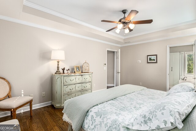 bedroom with ceiling fan, dark wood-style flooring, baseboards, crown molding, and a tray ceiling