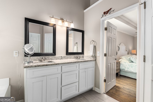 full bathroom with a sink, connected bathroom, crown molding, double vanity, and wood finished floors