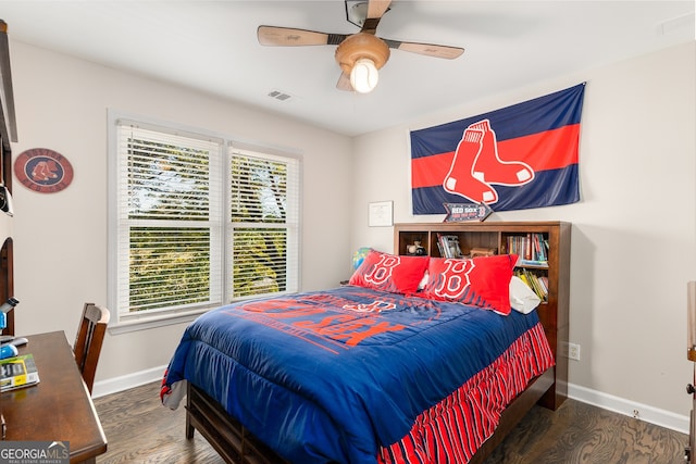 bedroom featuring wood finished floors, visible vents, a ceiling fan, and baseboards