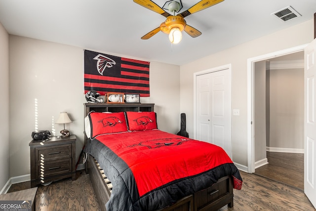 bedroom with wood finished floors, a closet, ceiling fan, baseboards, and visible vents