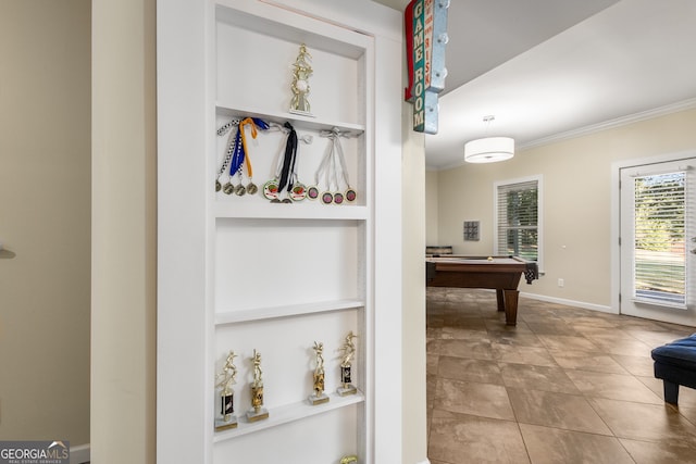 interior space with ornamental molding, built in shelves, billiards, and baseboards