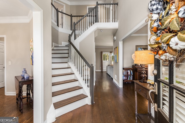 foyer with stairway, wood finished floors, ornamental molding, and baseboards