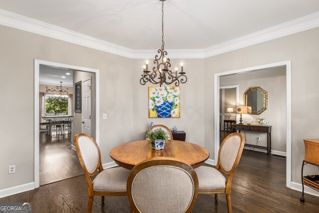 dining area featuring ornamental molding, dark wood-style floors, an inviting chandelier, and baseboards