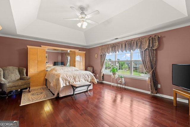 bedroom featuring a raised ceiling, baseboards, wood finished floors, and visible vents