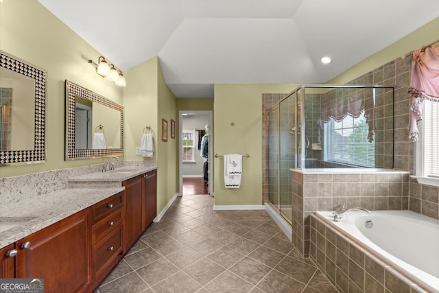 bathroom featuring a garden tub, vaulted ceiling, a shower stall, vanity, and tile patterned floors