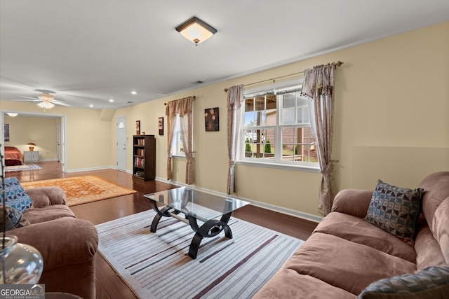 living room featuring a ceiling fan, visible vents, wood finished floors, baseboards, and recessed lighting
